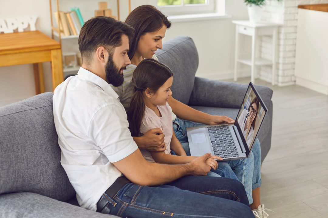 Family doctor online. Happy family consults using video conference computer at home.