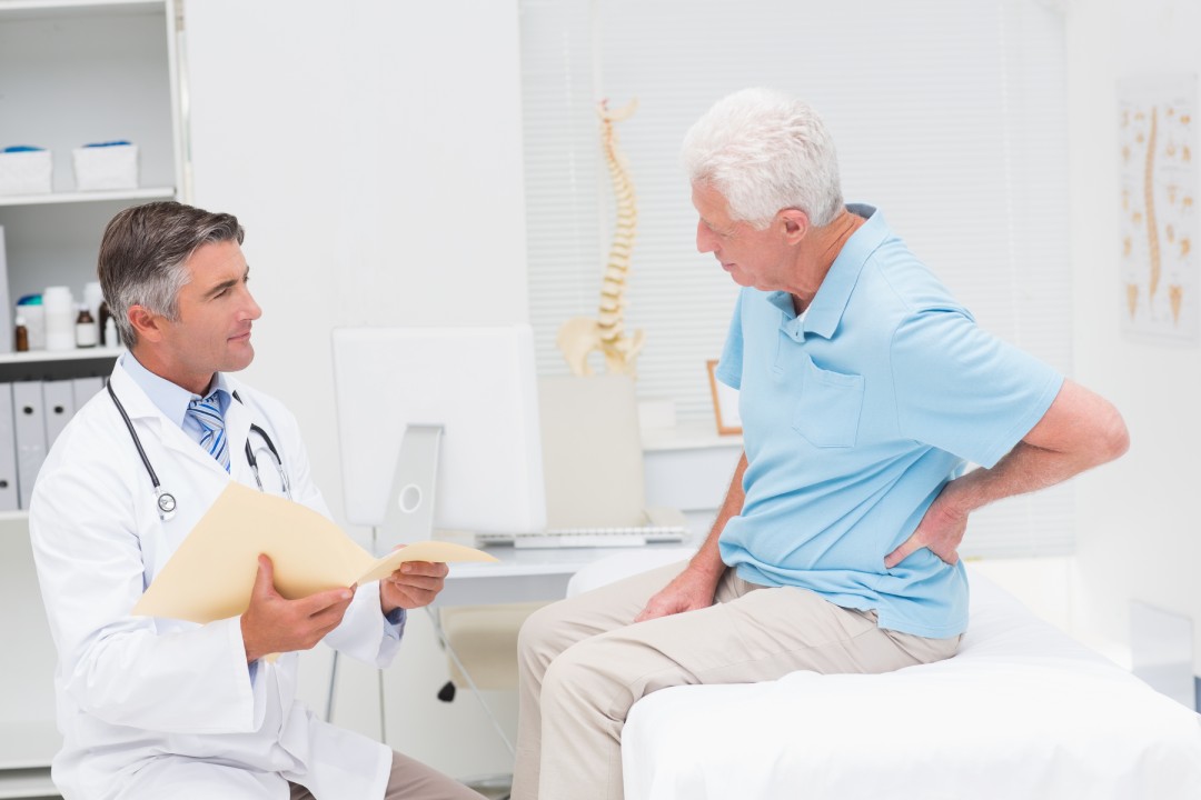 Male doctor discussing reports with senior patient