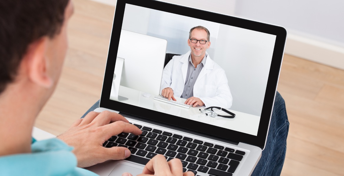 Man having video chat with doctor on laptop at home